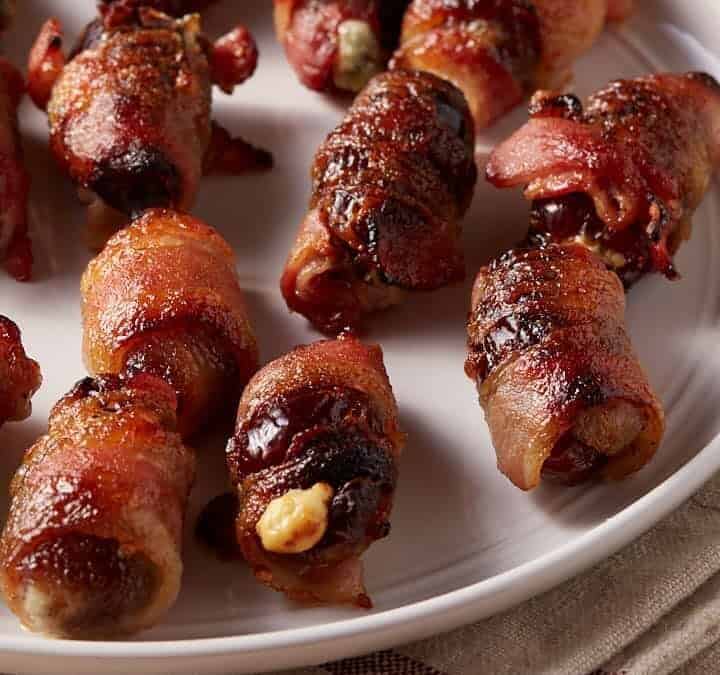 A platter of bacon wrapped stuffed dates.