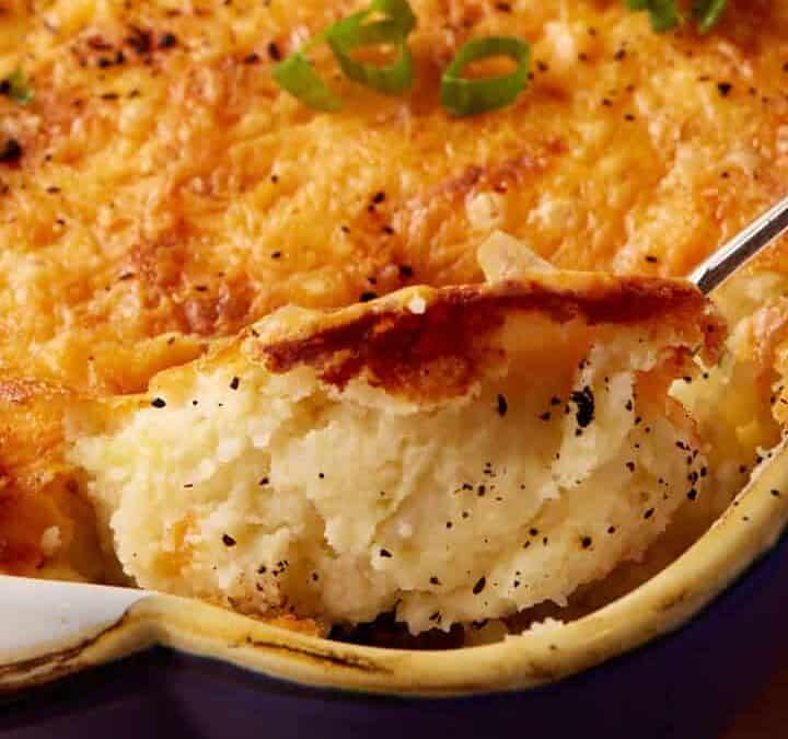 A spoon full of twice baked mashed potatoes.