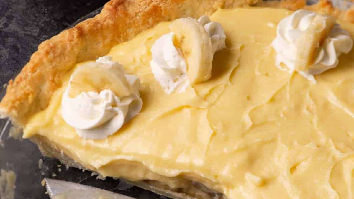 Part of a banana cream pie with a pie server.