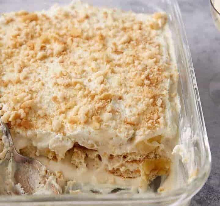 A baking dish of banana pudding with a serving spoon.