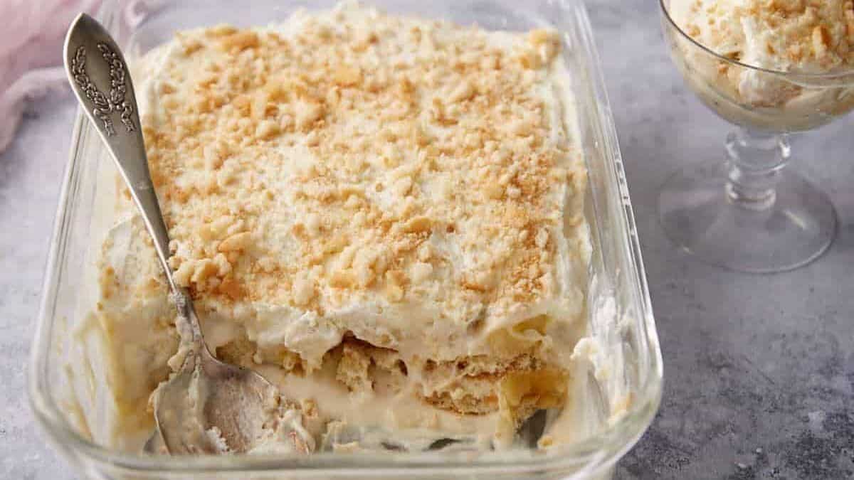 A baking dish of banana pudding with a serving spoon.