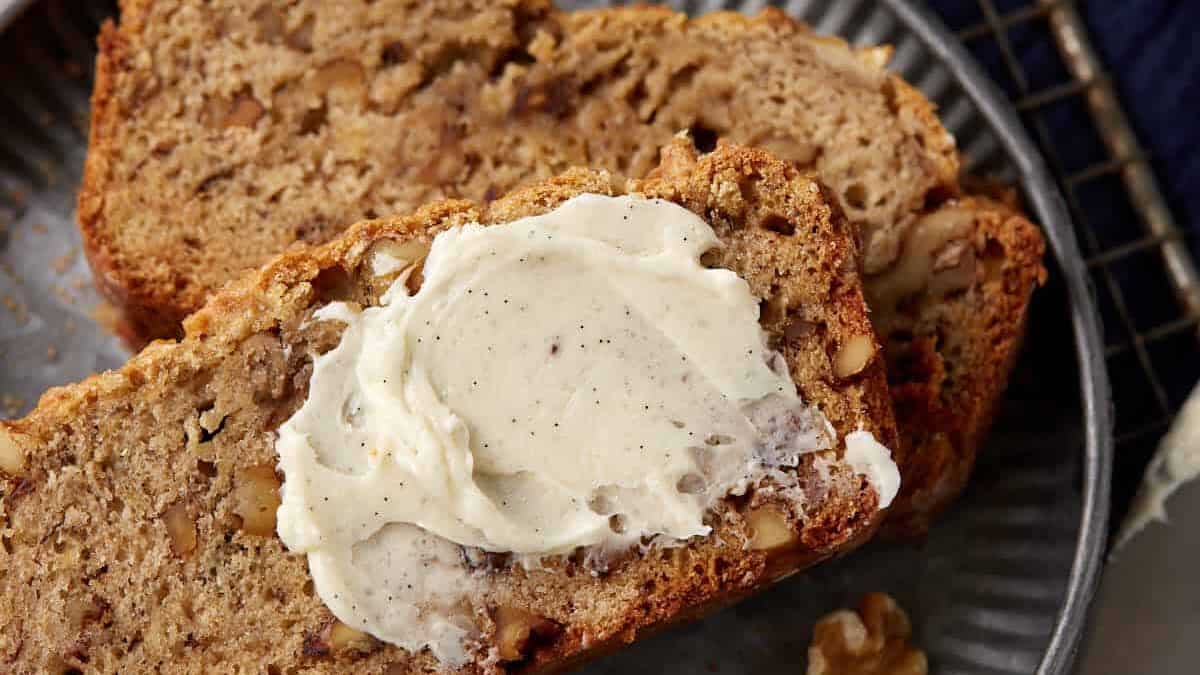 Sliced banana bread topped with vanilla butter.