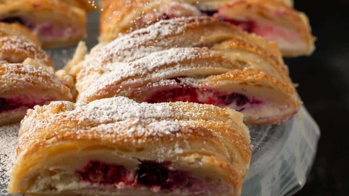 Powdered sugar being sprinkled over cream cheese puff pastry.