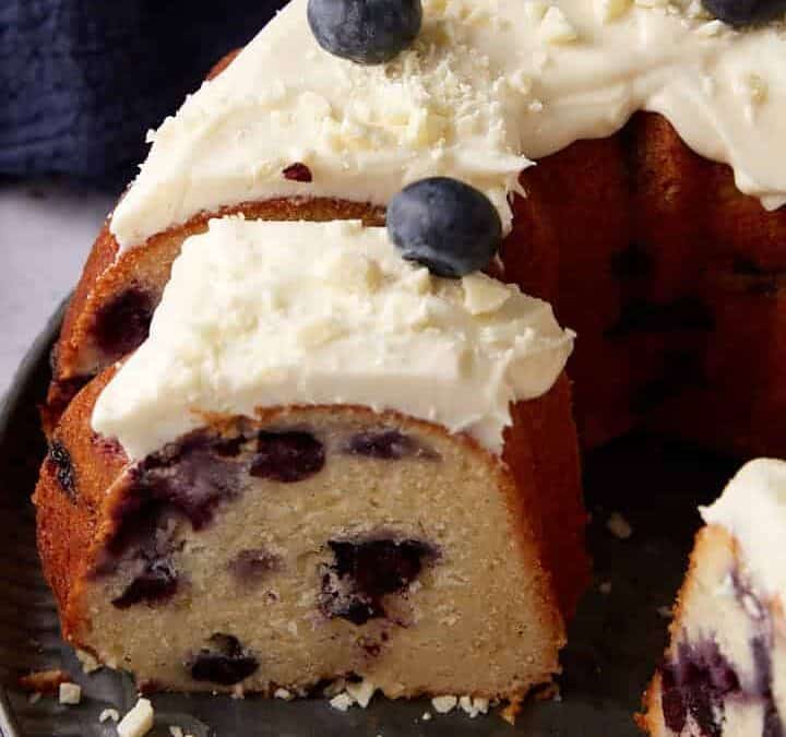 A blueberry cake with slices removed.