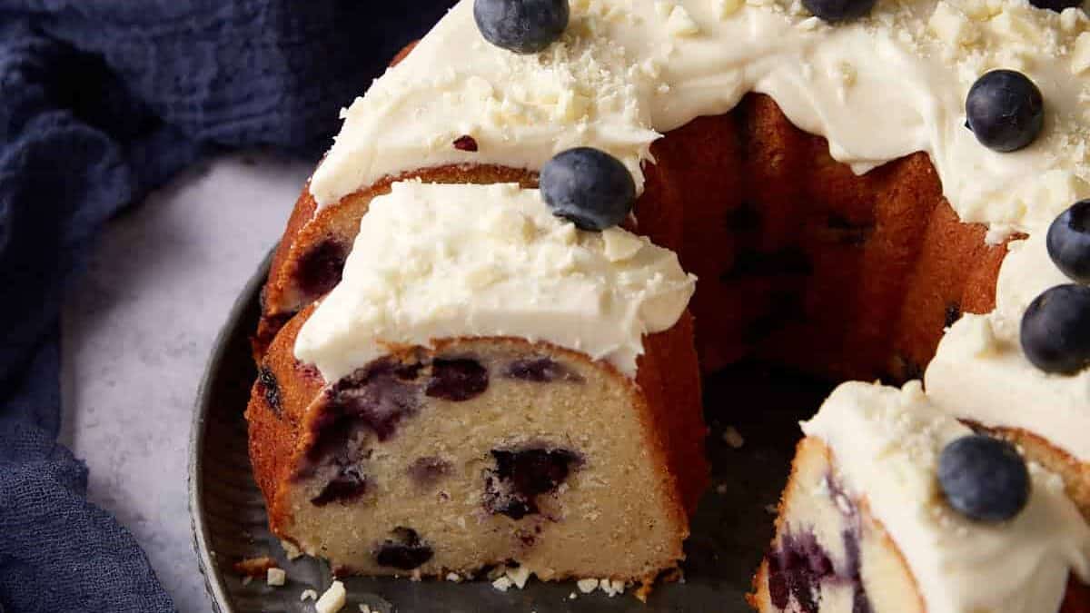 A blueberry cake with slices removed.