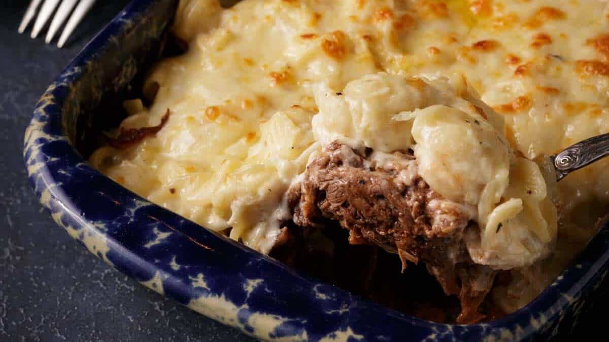 A spoon full of brisket with macaroni and cheese.