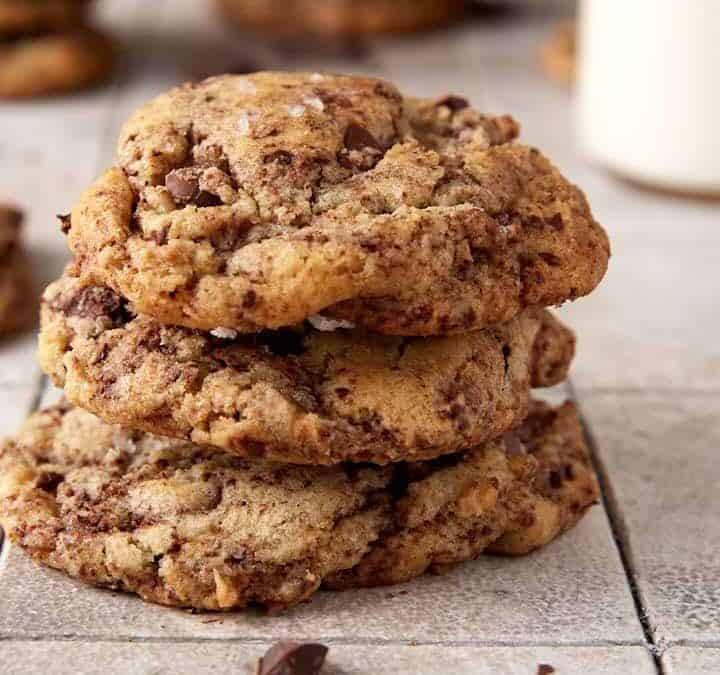A stack of cookies next to a bottle of milk.