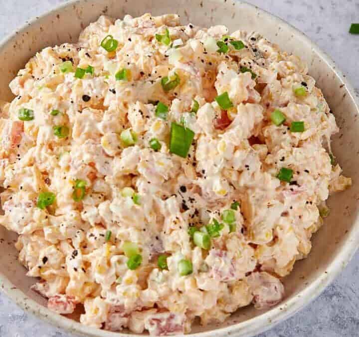 Corn dip in a bowl next to chips.