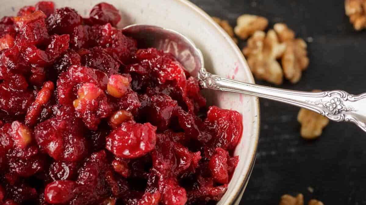 A bowl of cranberry sauce with a bottle of grand marnier.
