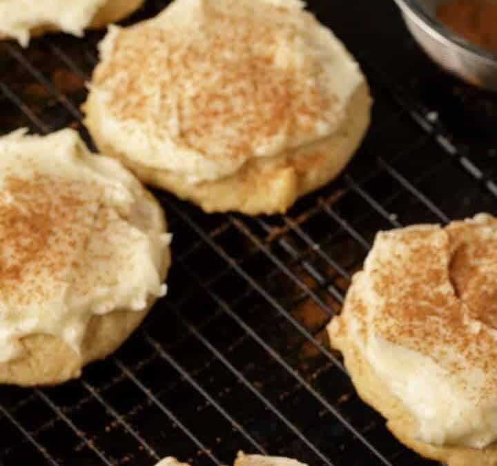 A rack of frosted eggnog cookies with cinnamon for sprinkling.