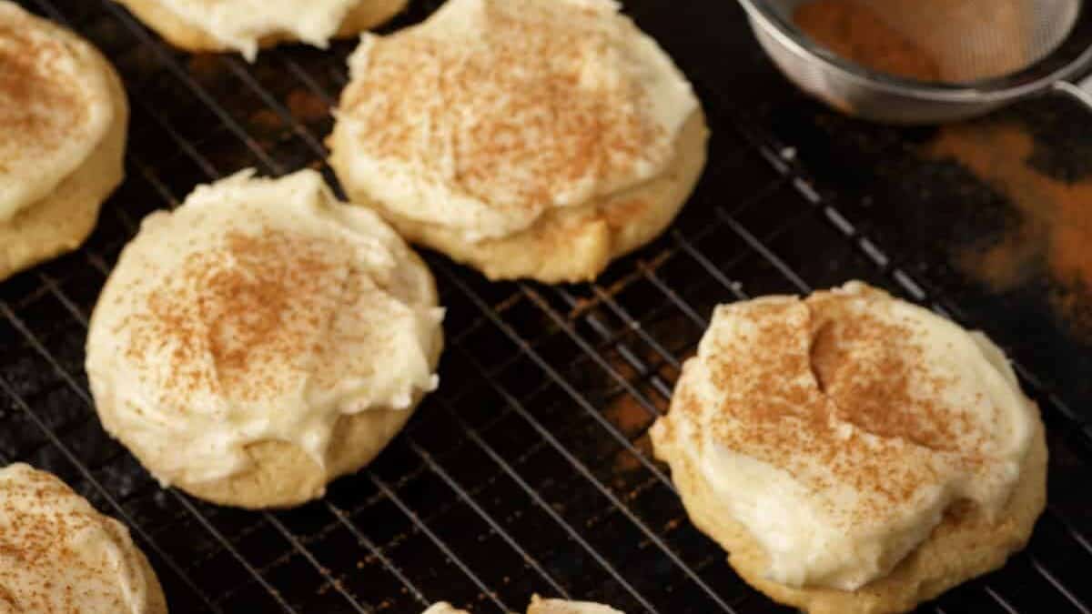 A rack of frosted eggnog cookies with cinnamon for sprinkling.