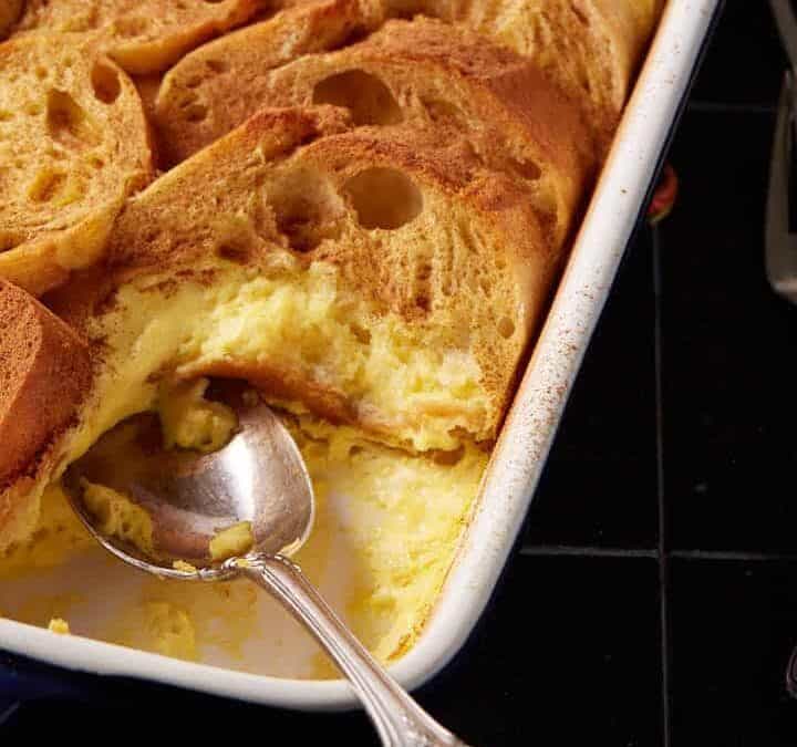 An eggnog overnight casserole next to coffee cups.