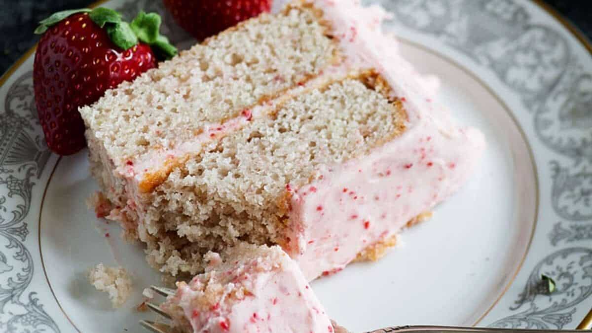 A bite out of a slice of strawberry cake