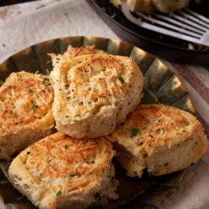 Garlic dinner rolls stacked on a platter.