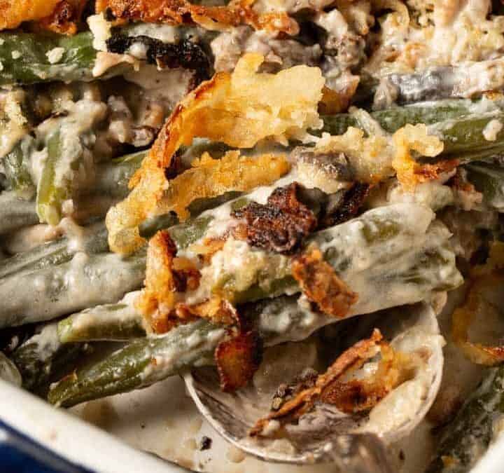 A serving spoon in a green bean casserole made from scratch,