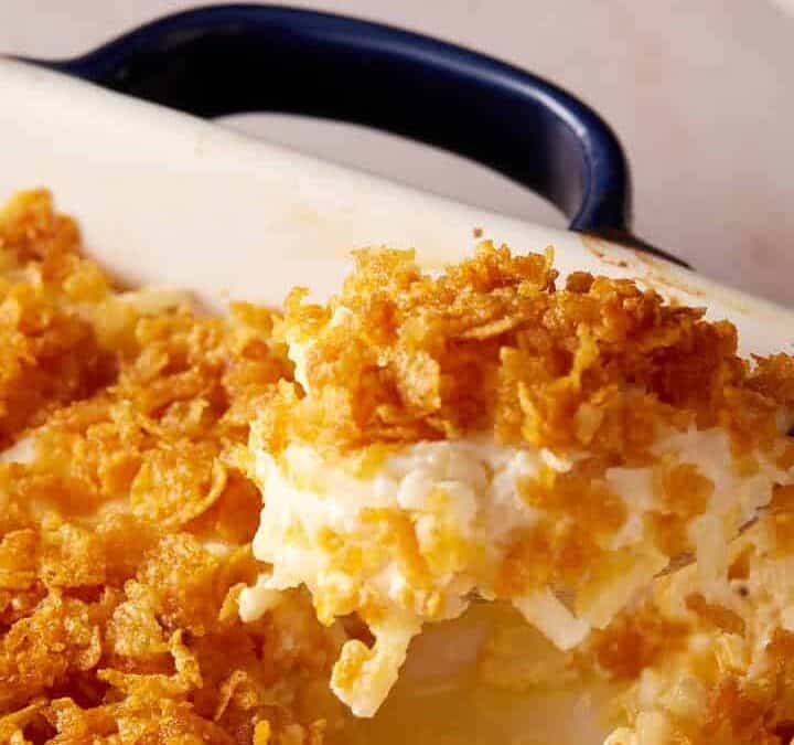 A spoon full of hashbrown casserole.