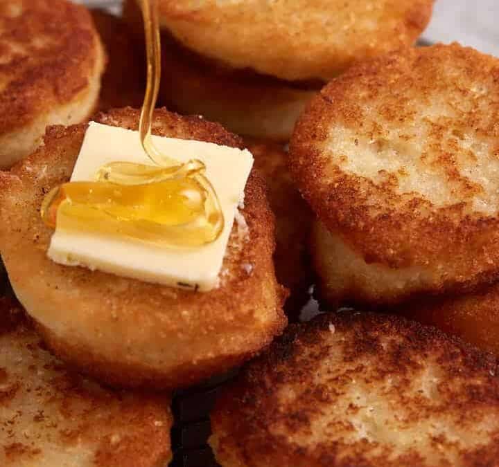 A rack of hot water cornbread with butter and honey.