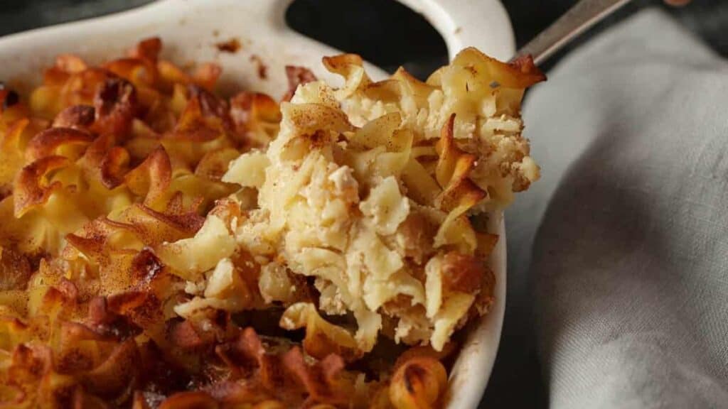 A serving spoon of noodle kugel.