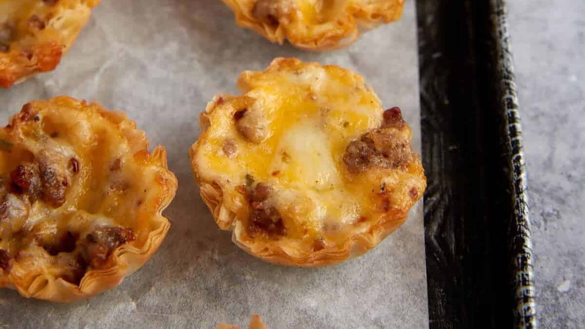 Sausage phyllo cups on parchment paper.