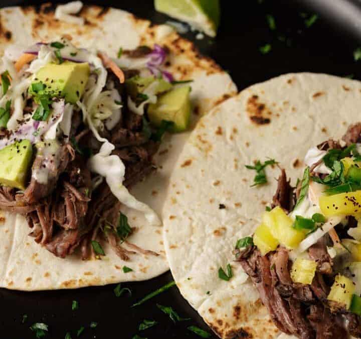 Two beef tacos on a platter.