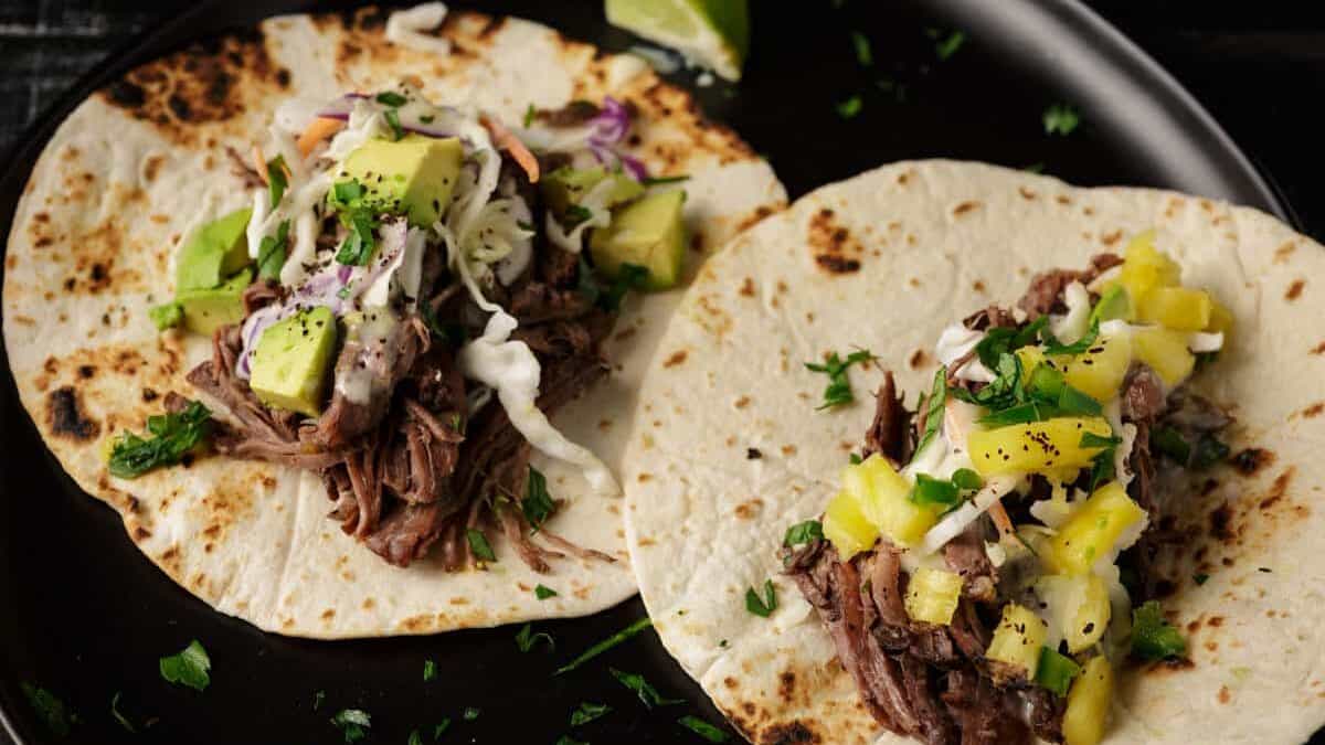 Two beef tacos on a platter.