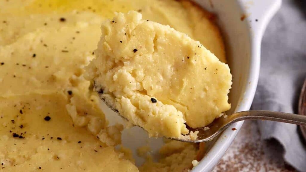 A serving spoon full of spoon bread.