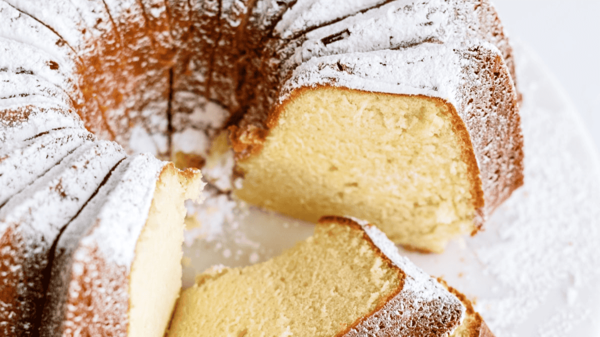 A close-up of an easy Bundt cake dusted with powdered sugar, showing its moist, golden interior and beautifully patterned outer crust.