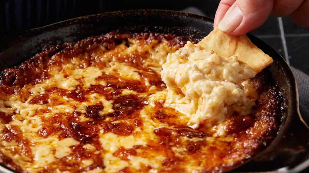 A scoop of onion dip on a pita chip.