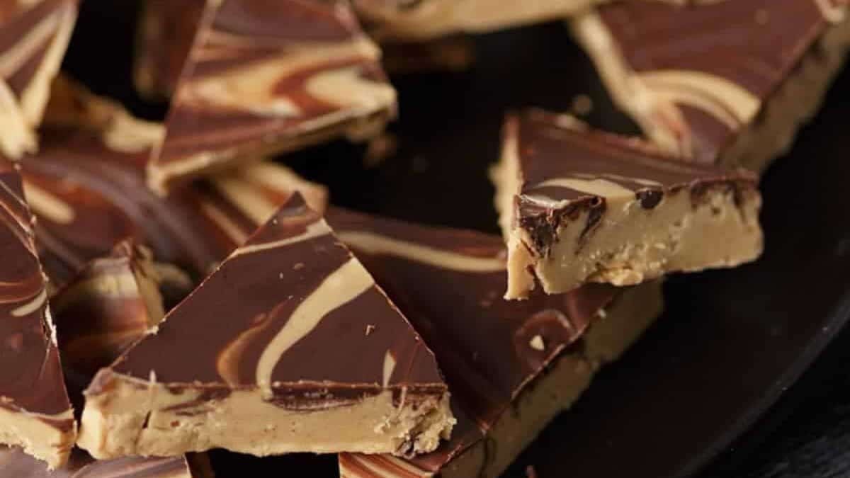 Triangular pieces of swirled chocolate and peanut butter fudge are arranged closely together, featuring a marbled pattern and creamy, dense texture—perfect for those who love the rich taste of chocolate chips in desserts.