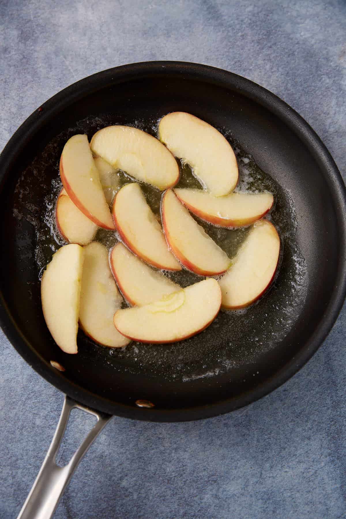 Sliced apples in a skillet.