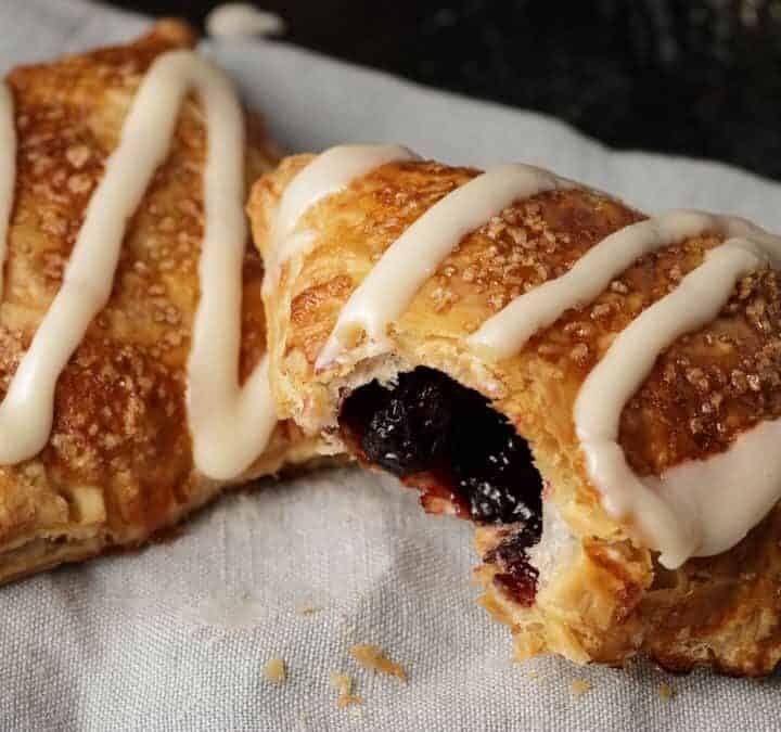 Cherry hand pies on a linen napkin with a bite taken out