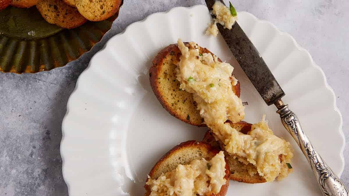 A small plate with crostini and crab dip.