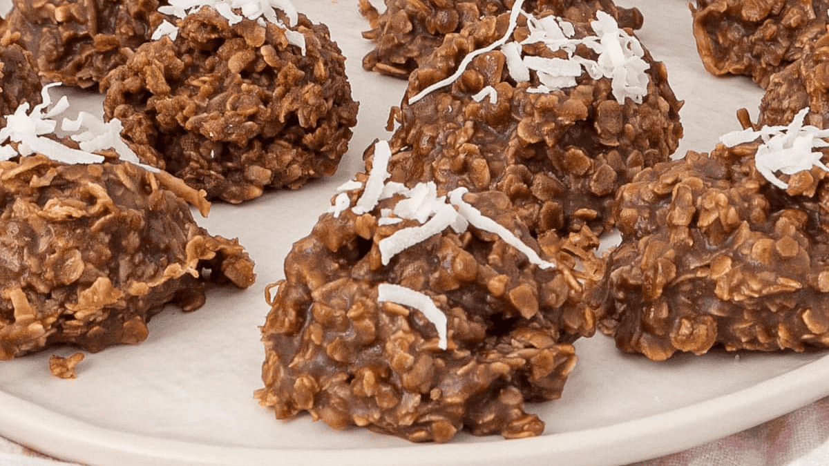 Chocolate oatmeal no-bake cookies topped with shredded coconut make perfect no bake Thanksgiving desserts, served on a white plate.