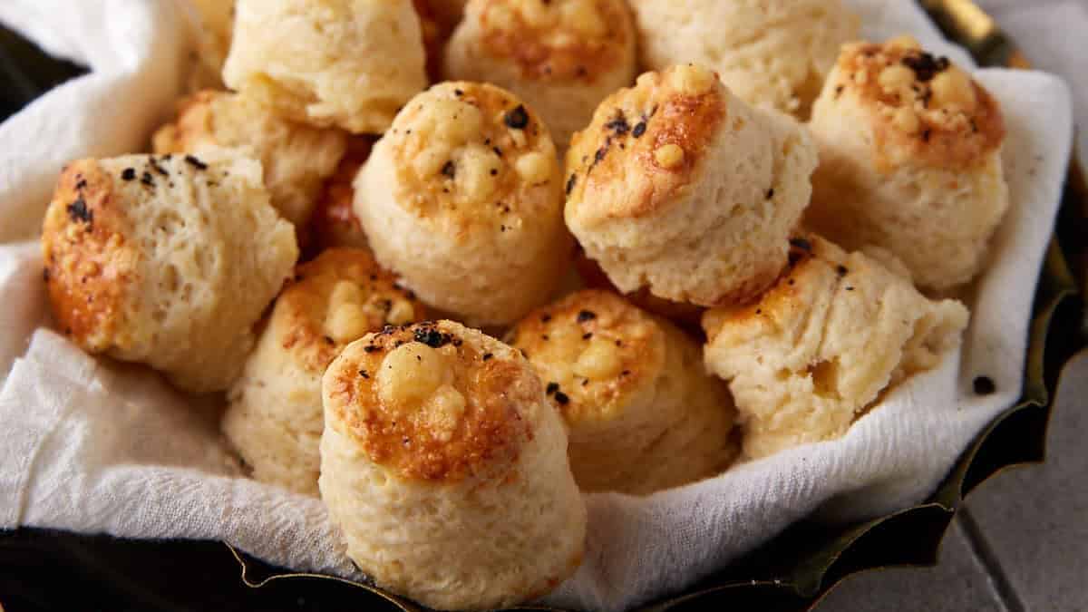 Mini Parmesan biscuits stacked on a plate and golden brown.