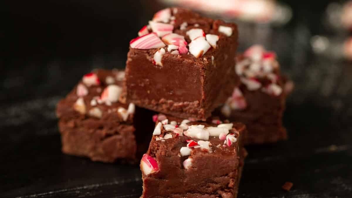 Christmas fudge stacked with candy canes in the background.