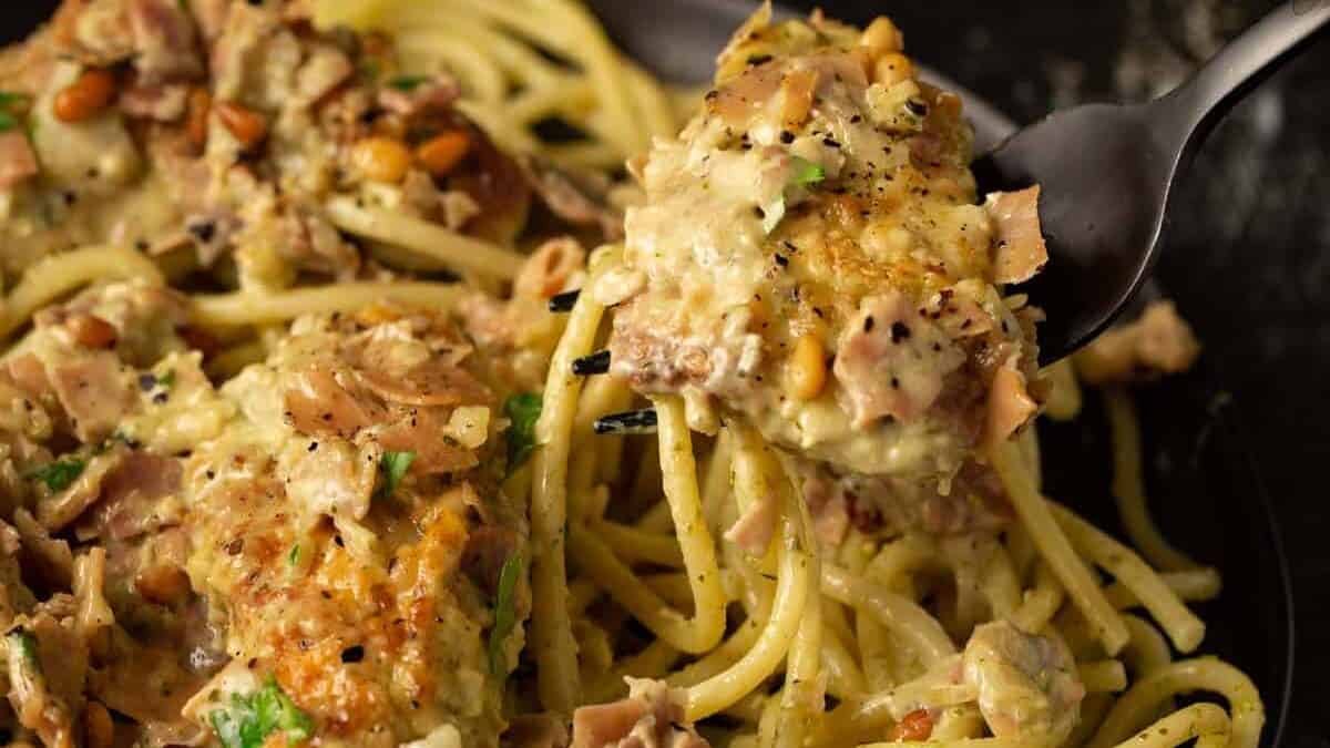 A Fork pulling out a serving of pesto chicken.