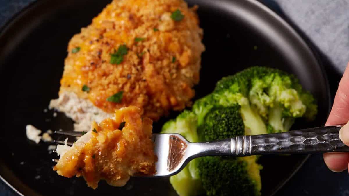 A fork with a bite of chicken.