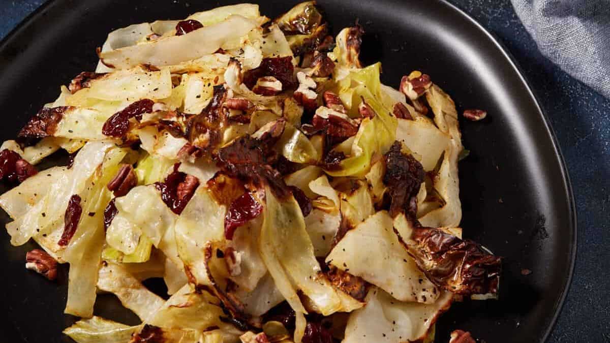 Cabbage roasted in the oven with cherries on a platter.