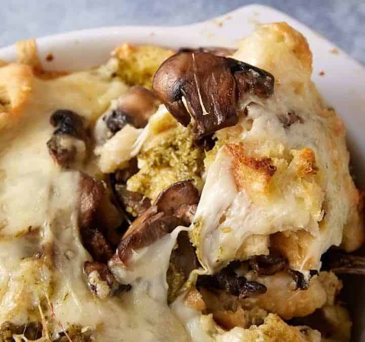 A spoon scooping out a serving of savory bread pudding.