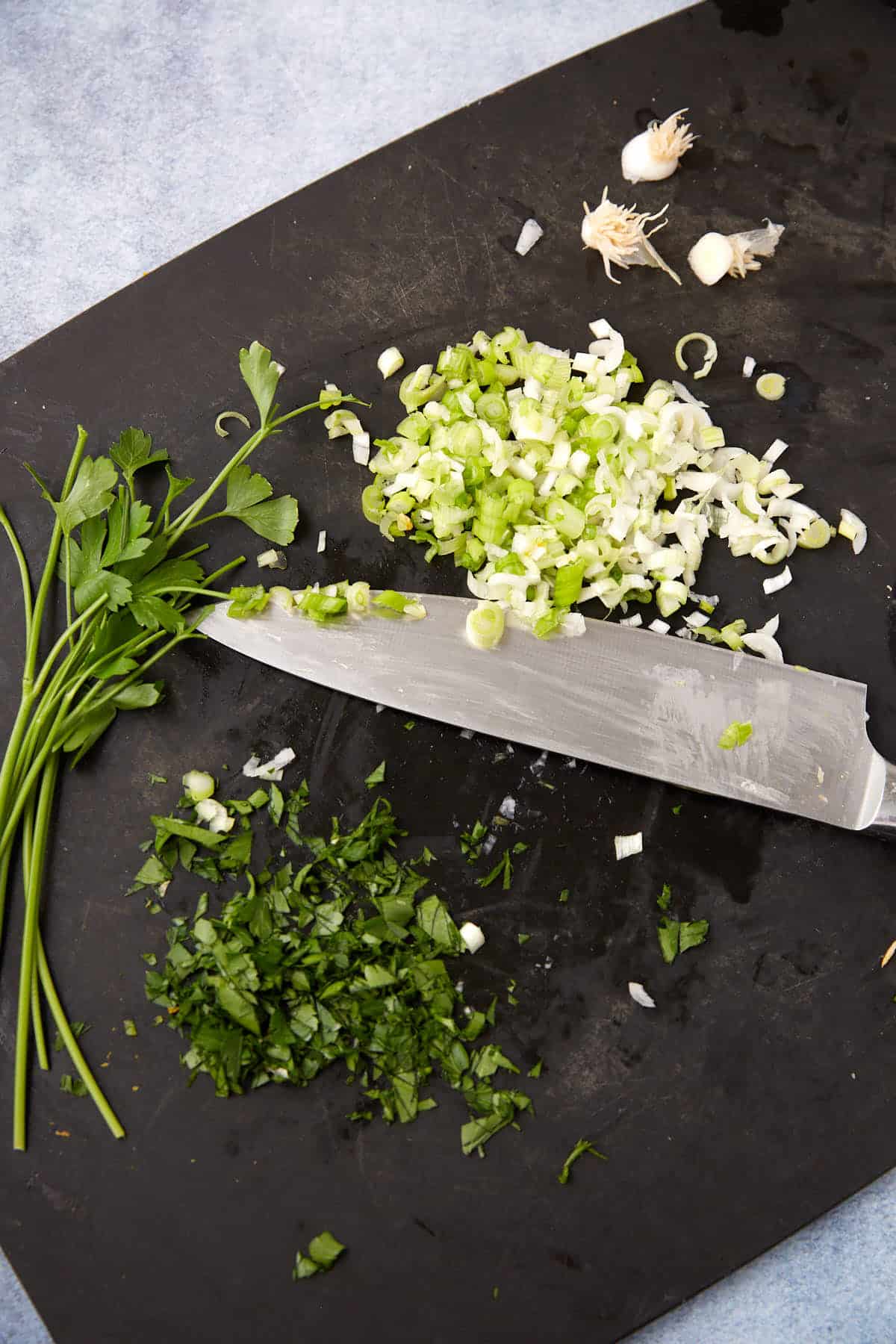 Onions and parsley cut on a cutting board.