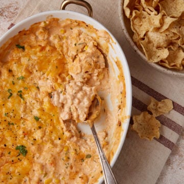 A spoon in a casserole dish of seafood dip.