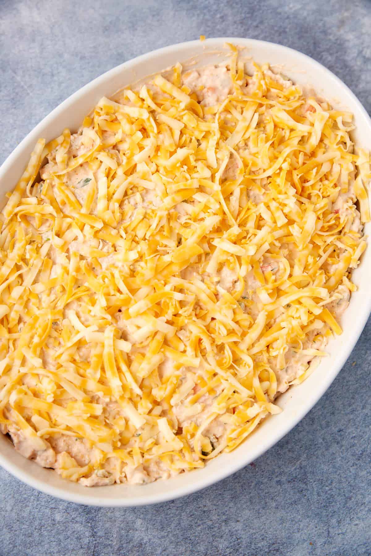 Cheese sprinkled on the top of a seafood dip.