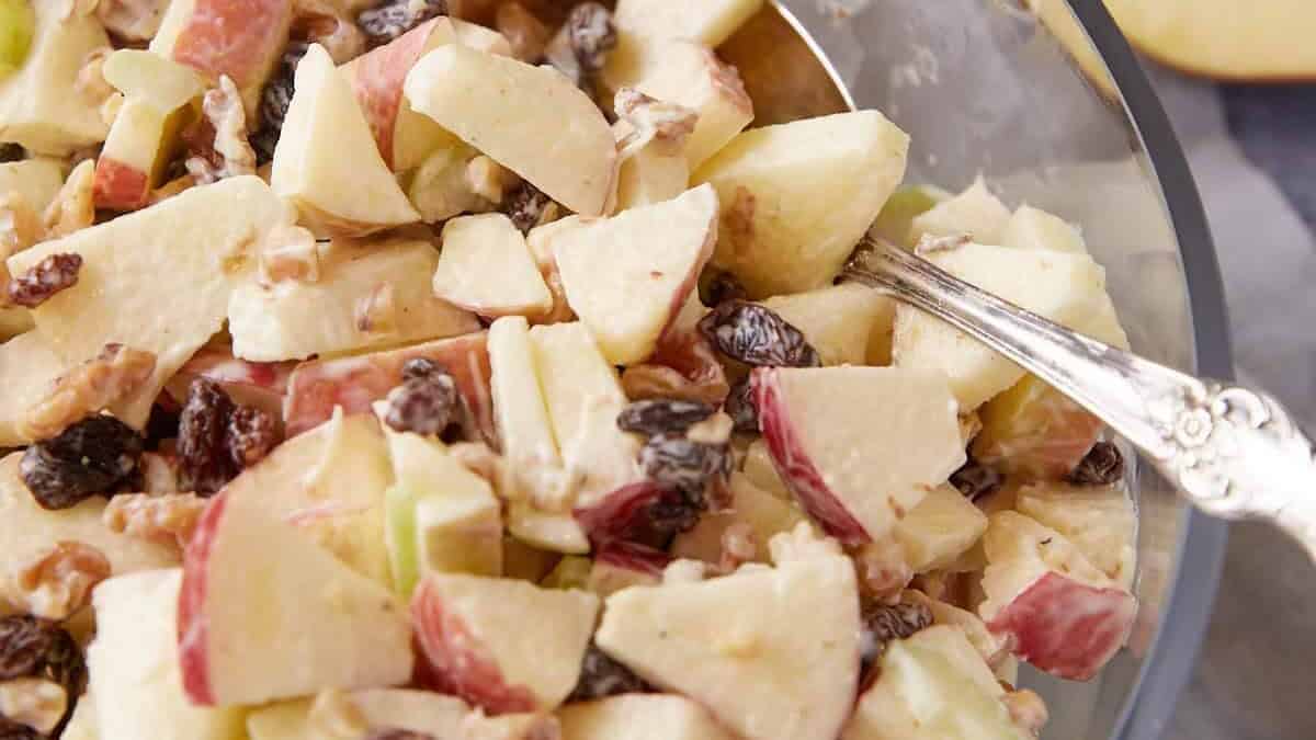 A serving spoon in a bowl of apple waldorf salad.