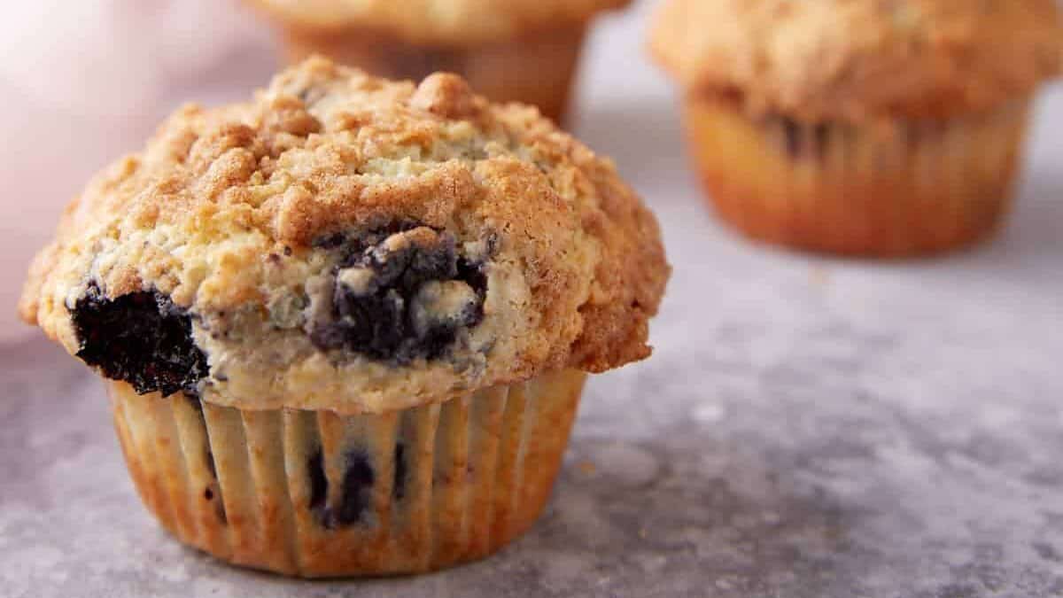 Berry muffins with bottles of milk in the background.