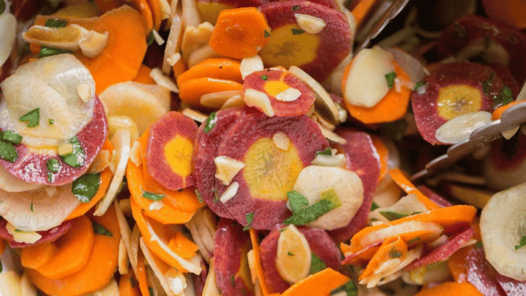 A pile of sliced carrots and onions in a bowl.
