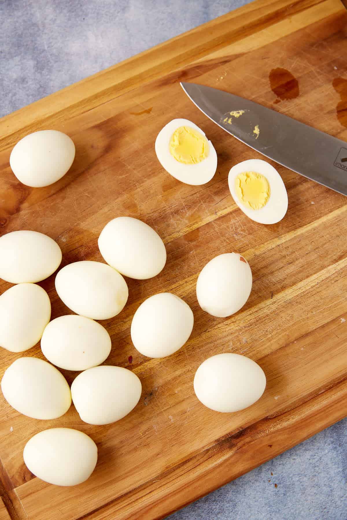 Eggs cut into half on a cutting board.