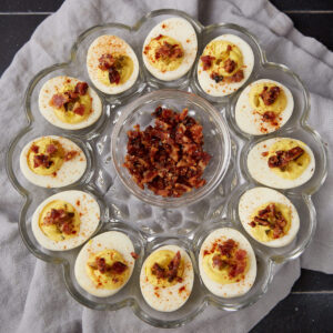 Deviled eggs on a glass platter.