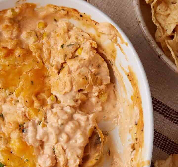 A spoon in a casserole dish of seafood dip.