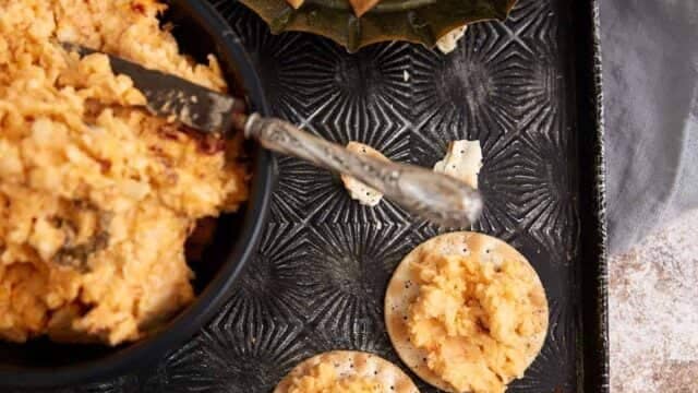 A tray of pimento cheese dip on crackes.