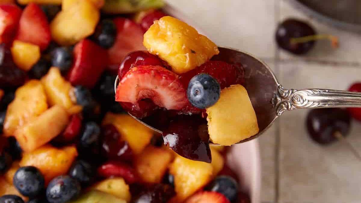 A spoon Full of fresh fruit.